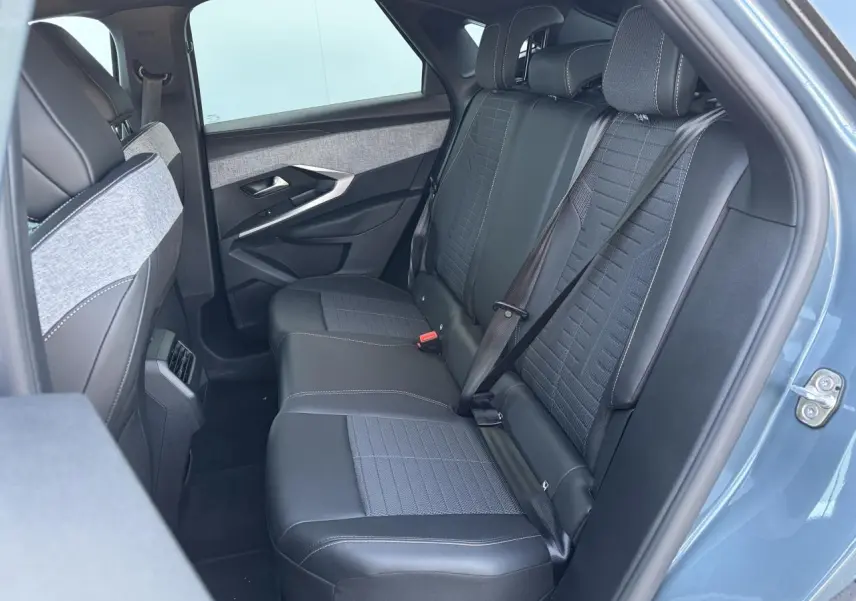 Vue intérieure arrière côté droit du Peugeot 3008 bleu Ingara, sièges tissu et cuir avec ceintures attachées.