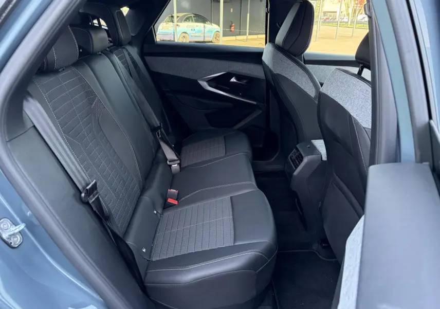 Vue intérieure côté gauche sur la banquette arrière tissu et cuir du Peugeot 3008 bleu Ingaro 2024.
