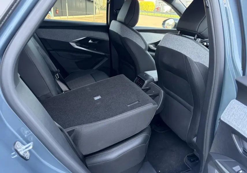 Vue intérieure arrière côté gauche du Peugeot 3008 bleu Ingaro avec dossier de banquette rabattable et sellerie mixte tissu et cuir.