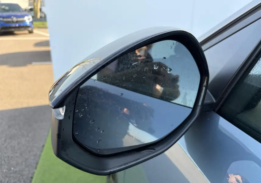 Rétroviseur extérieur droit bleu Ingaro du Peugeot 3008 2024 avec gouttes d'eau et éclairage naturel.