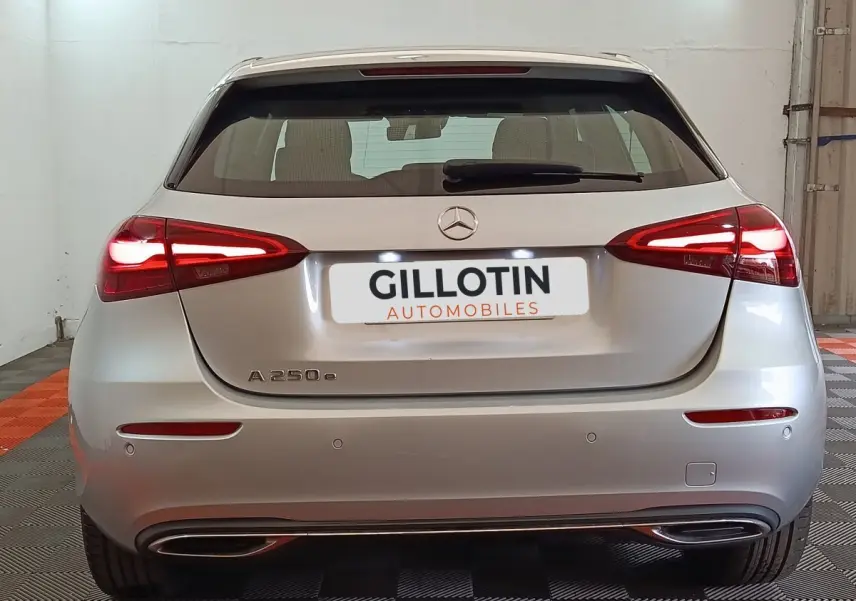 Vue arrière d'une Mercedes GLA 250 e hybride rechargeable gris foncé avec feux LED allumés dans un garage.