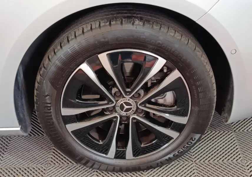 Gros plan sur la roue avant droite d'une Mercedes GLA 250 e gris foncé avec jante alliage noir et argentée.