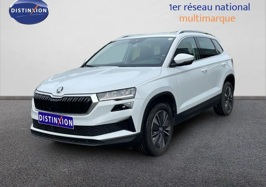SUV Skoda Karoq blanc glacier vu en 3/4 avant droit avec calandre noire et jantes bi-ton.