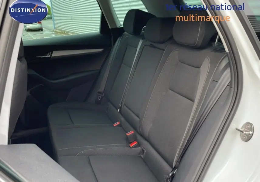 Vue intérieure côté gauche montrant la banquette arrière en tissu noir du Skoda Karoq blanc glacier 2025.