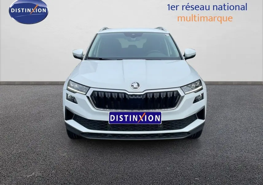 Vue de face d’un Skoda Karoq blanc glacier 2025 avec calandre noire et phares LED distinctifs.