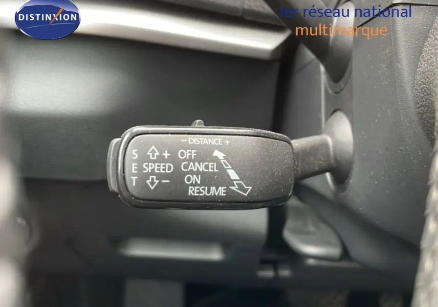 Gros plan sur la commande de régulateur de vitesse du Skoda Karoq blanc glacier, intérieur noir.