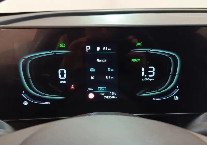 Affichage numérique du tableau de bord du Kia Sportage hybride rechargeable, indiquant vitesse, régime et autonomie.
