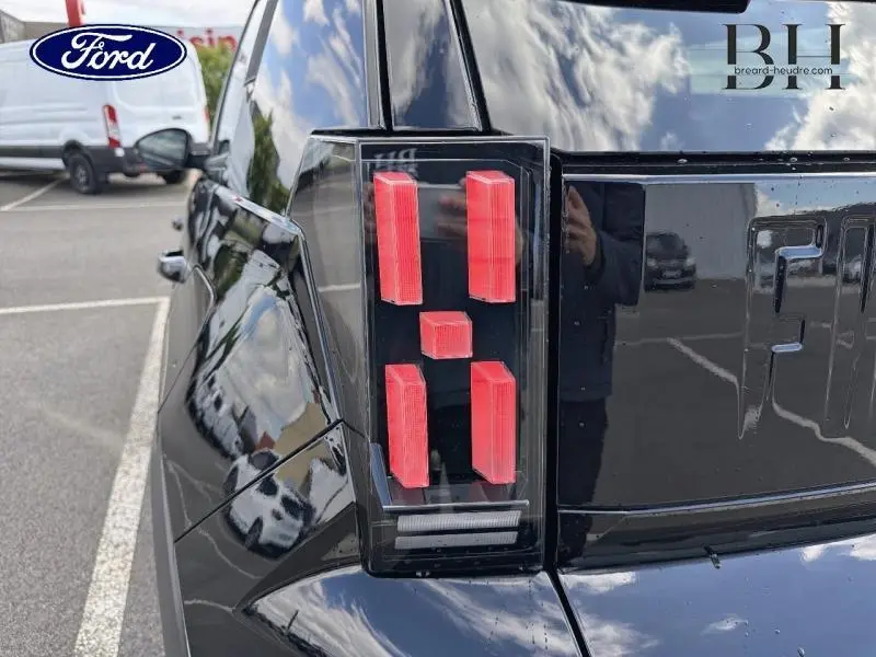 Gros plan sur le feu arrière droit noir métallisé de la Fiat Grande Panda 2025 avec logo FIAT en relief.