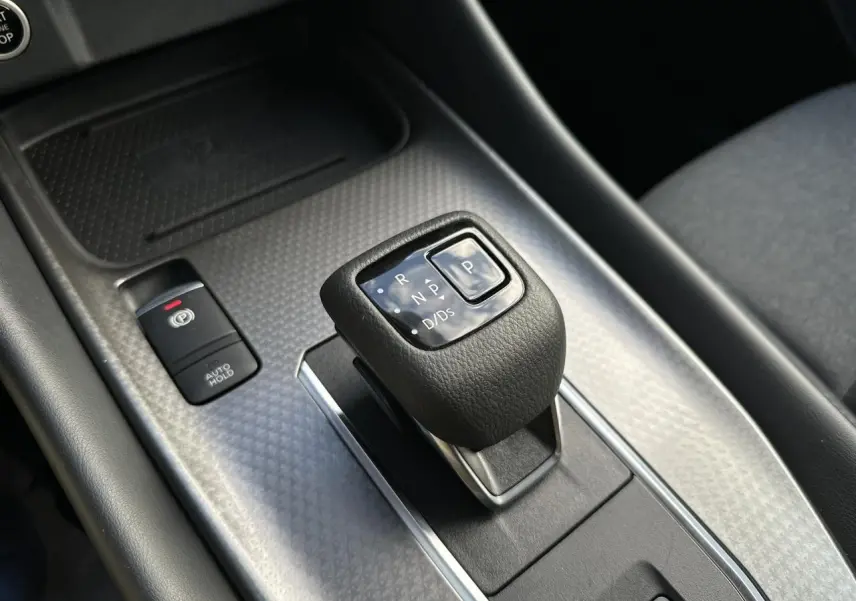 Gros plan sur le levier de vitesses automatique et frein à main électrique du Nissan Qashqai 2025, intérieur noir.