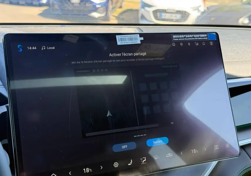 Gros plan sur l'écran tactile central du tableau de bord du BYD SEAL U 1.5 DM-i en intérieur, avec reflet extérieur.
