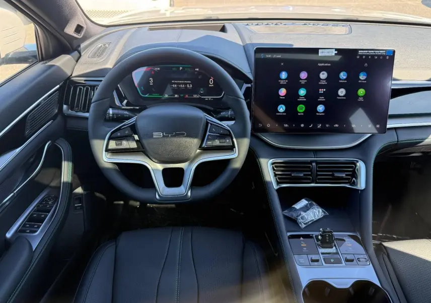 Vue intérieure frontale du tableau de bord du BYD SEAL U avec volant multifonction et grand écran tactile central.