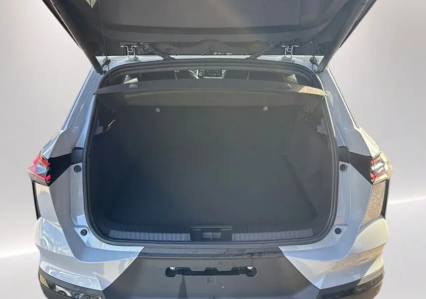 Vue arrière du coffre ouvert du Renault Symbioz gris rafale, mettant en valeur l'espace de chargement et les feux arrière LED.