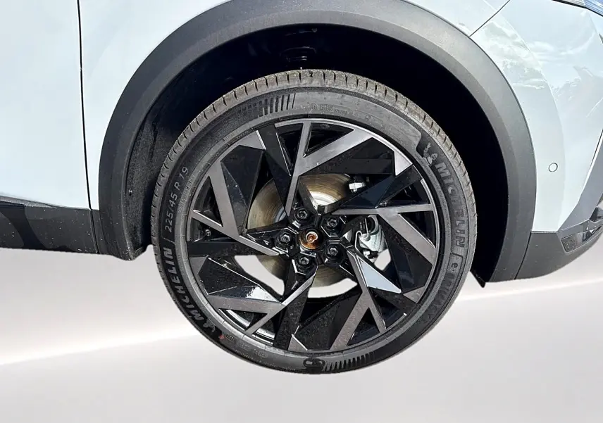 Gros plan sur la roue avant droite du Renault Symbioz gris rafale, mettant en valeur la jante alu noire au design géométrique.