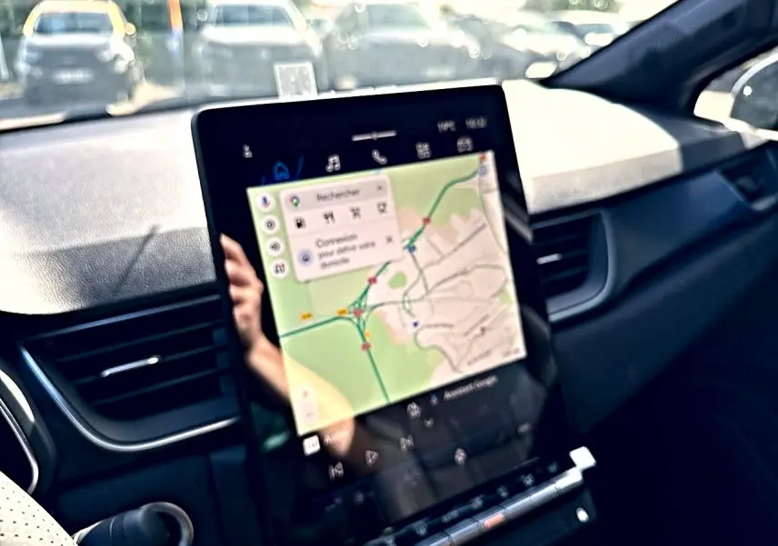 Vue intérieure du tableau de bord du Renault Symbioz gris rafale, écran tactile affichant un GPS cartographique.
