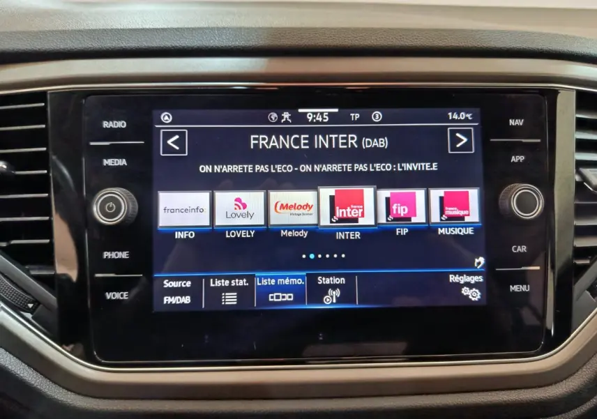 Écran tactile central affichant les stations radio dans l'habitacle du Volkswagen T-Roc gris foncé, vue rapprochée.