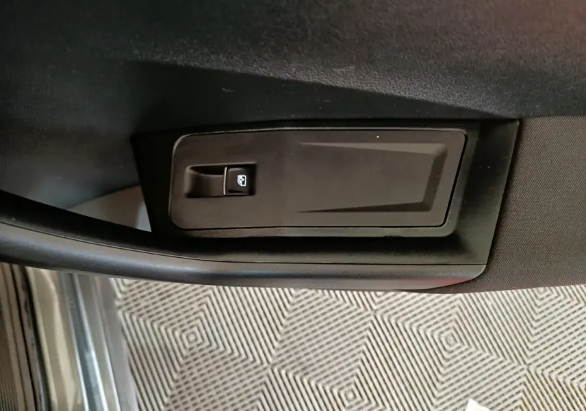 Poignée intérieure de porte côté gauche du Volkswagen T-Roc gris foncé, avec bouton de verrouillage des vitres.