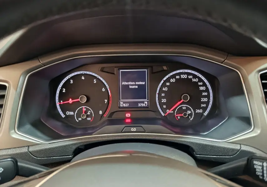 Vue rapprochée du tableau de bord numérique du Volkswagen T-Roc 2021, affichant un avertissement moteur.