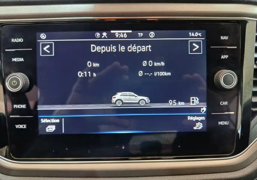 Écran tactile central affichant les données de trajet du Volkswagen T-Roc gris foncé en vue latérale droite.