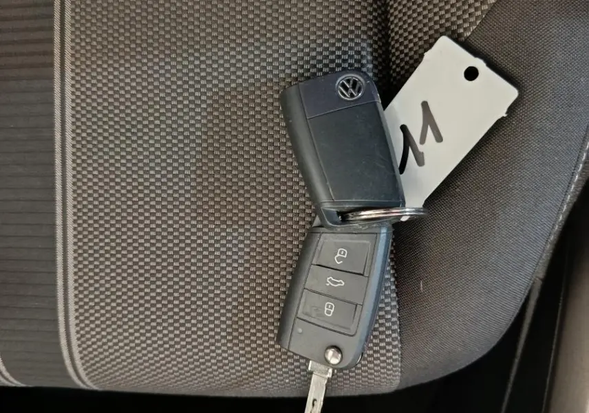 Clé Volkswagen posée sur un siège tissu gris foncé à motifs, intérieur du Volkswagen T-Roc 2021 visible partiellement.