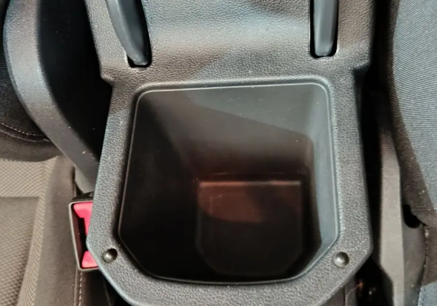 Gros plan sur le rangement central noir ouvert entre les sièges avant du Volkswagen T-Roc gris foncé 2021.