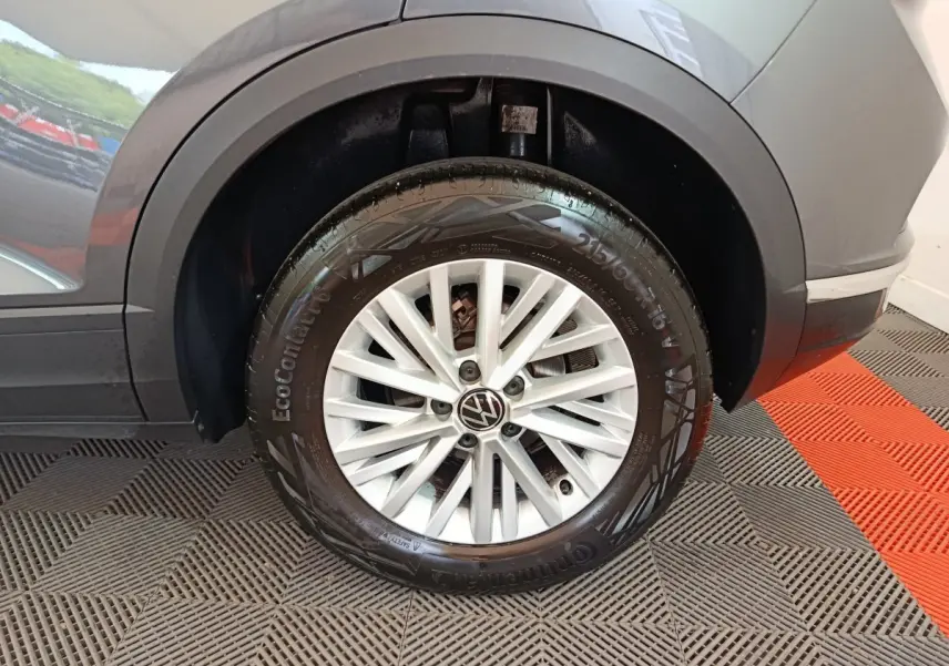 Gros plan sur la roue arrière droite grise foncée d'un Volkswagen T-Roc 2021 avec jante alliage à rayons fins blancs.