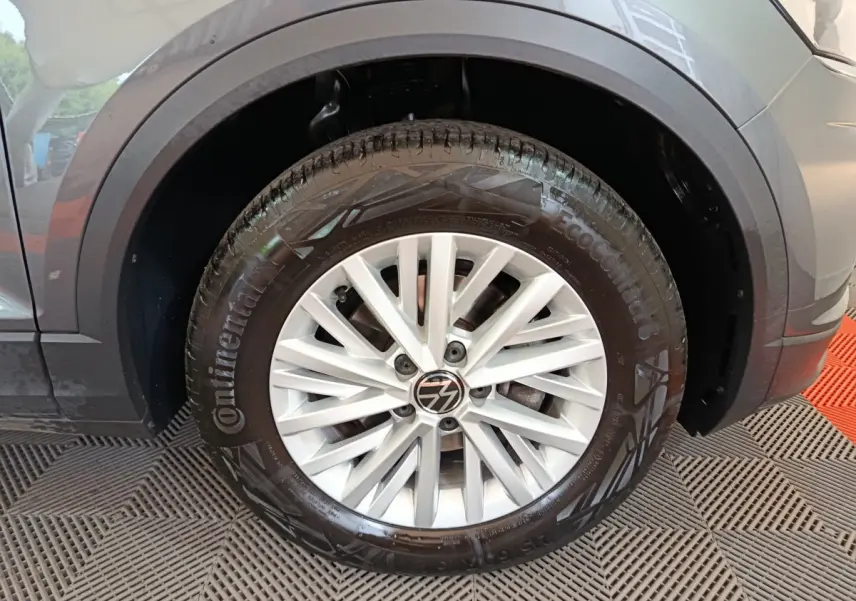 Gros plan sur la roue avant gauche du Volkswagen T-Roc gris foncé avec jante alliage et pneu Continental.