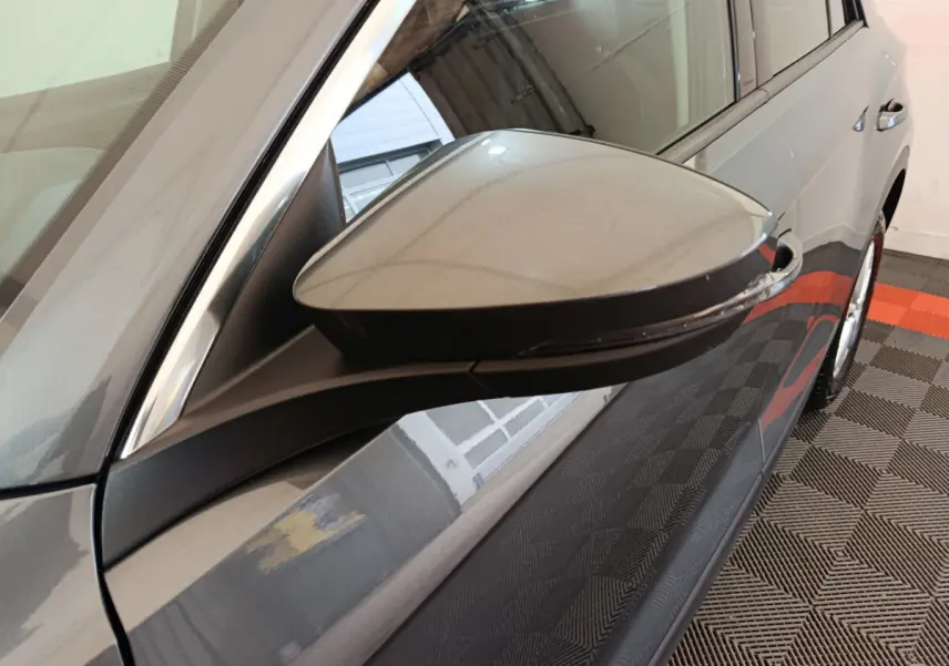 Rétroviseur côté gauche gris foncé du Volkswagen T-Roc 2021 avec clignotant intégré, vue rapprochée en intérieur.