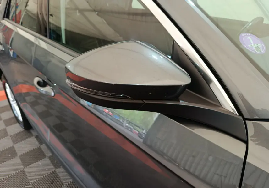 Rétroviseur côté gauche gris foncé du Volkswagen T-Roc 2021, avec poignée de porte et partie de la portière visible.