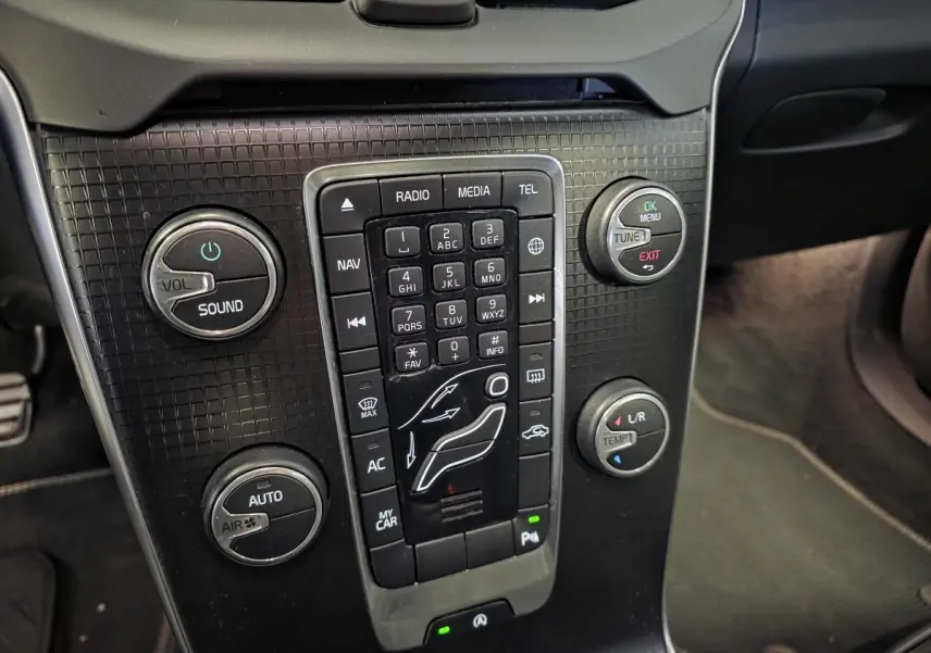 Gros plan sur la console centrale noire de la Volvo V40 D2 R-Design 2019 avec commandes de climatisation et audio.