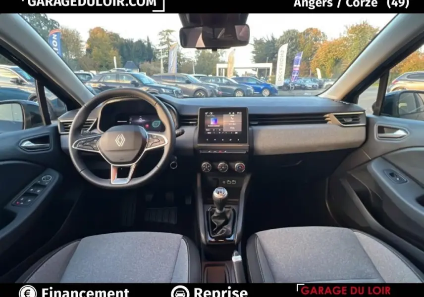 Vue intérieure avant de la Renault Clio noire 2025 montrant le volant cuir multifonctions et l’écran tactile central.