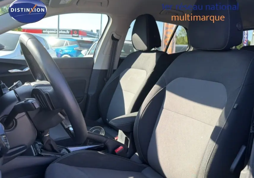 Vue intérieure côté conducteur de la Skoda Fabia 2025 gris graphite, montrant les sièges en tissu et le volant multifonction cuir.