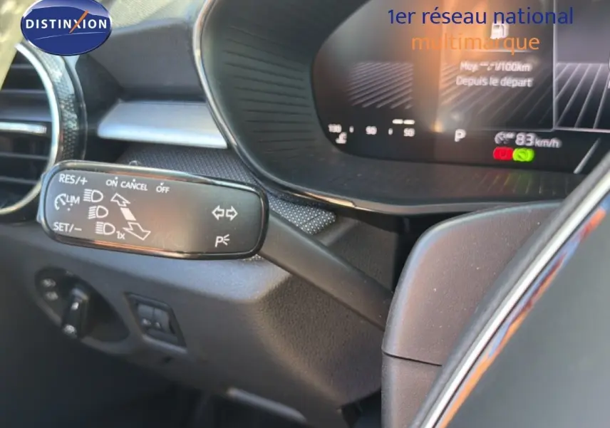 Gros plan sur la commande de régulateur de vitesse à gauche du volant dans l’habitacle gris foncé d’une Skoda Fabia 2025.