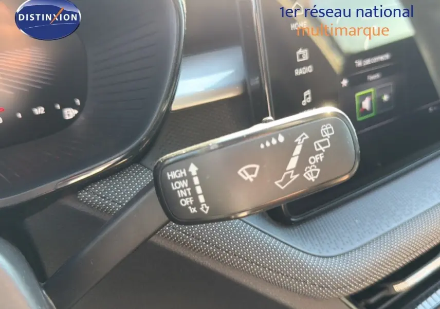 Gros plan sur les commandes gauche du volant cuir d’une Skoda Fabia gris graphite, tableau de bord en arrière-plan flou.