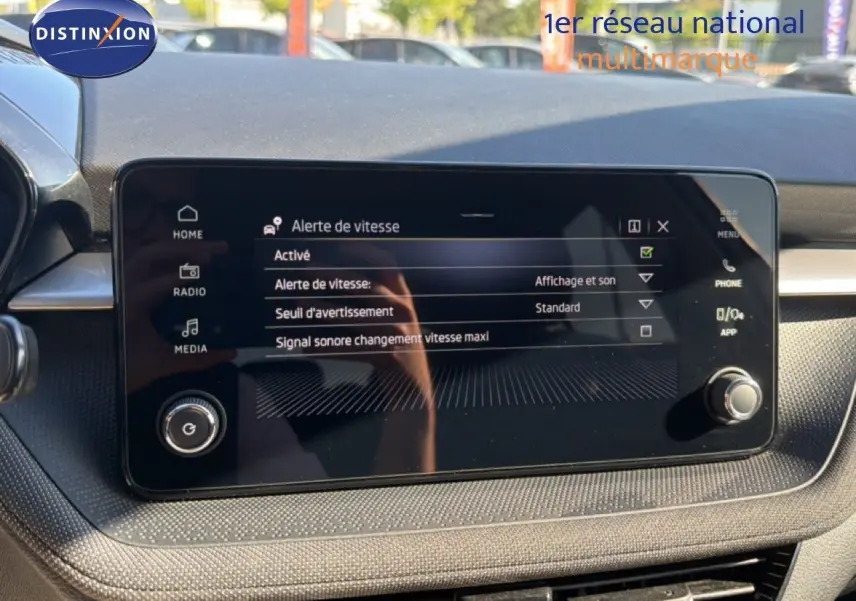 Vue rapprochée de l’écran tactile central du tableau de bord d’une Skoda Fabia gris graphite, affichant la radio FM/DAB.