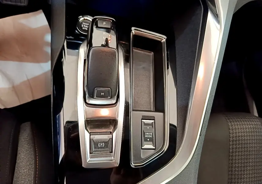 Gros plan sur la console centrale noire du Peugeot 3008 2022 avec levier de vitesse automatique et bouton Drive Mode.