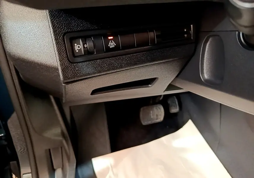 Vue intérieure côté conducteur du Peugeot 3008 bleu 2022, avec commandes d'éclairage et pédales visibles.