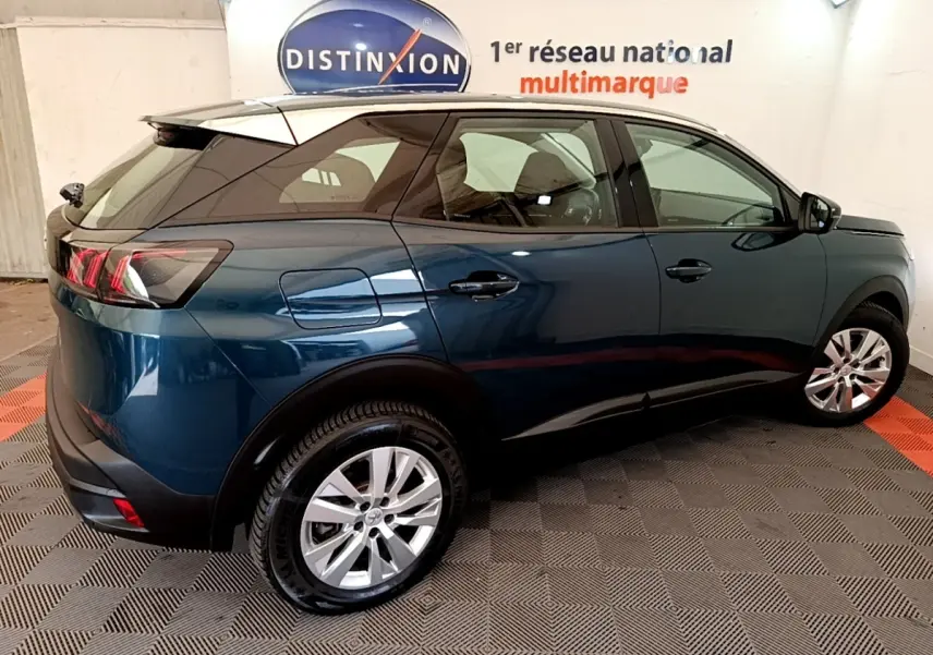Vue 3/4 arrière droite du Peugeot 3008 bleu 2022 avec toit noir et jantes alliage argentées.
