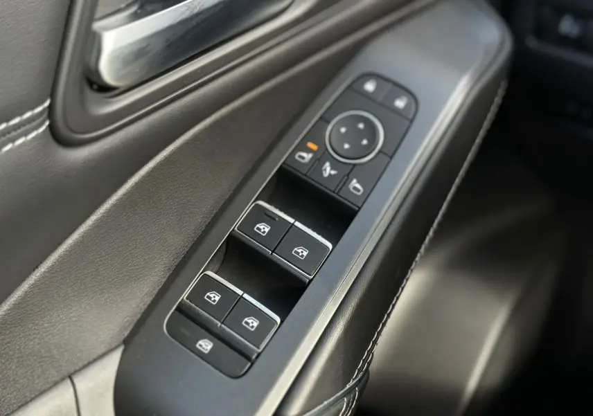 Gros plan sur les commandes des vitres électriques côté gauche intérieur du Nissan Qashqai blanc nacré 2025.