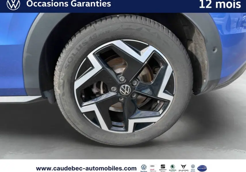 Gros plan sur la jante en alliage noir et argent du côté gauche d’un Volkswagen T-Roc bleu métallisé.
