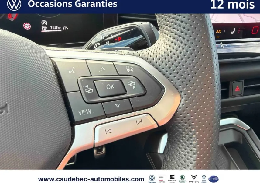 Gros plan sur le volant multifonction perforé noir du Volkswagen T-Roc 2026 avec commandes intégrées et tableau de bord numérique.
