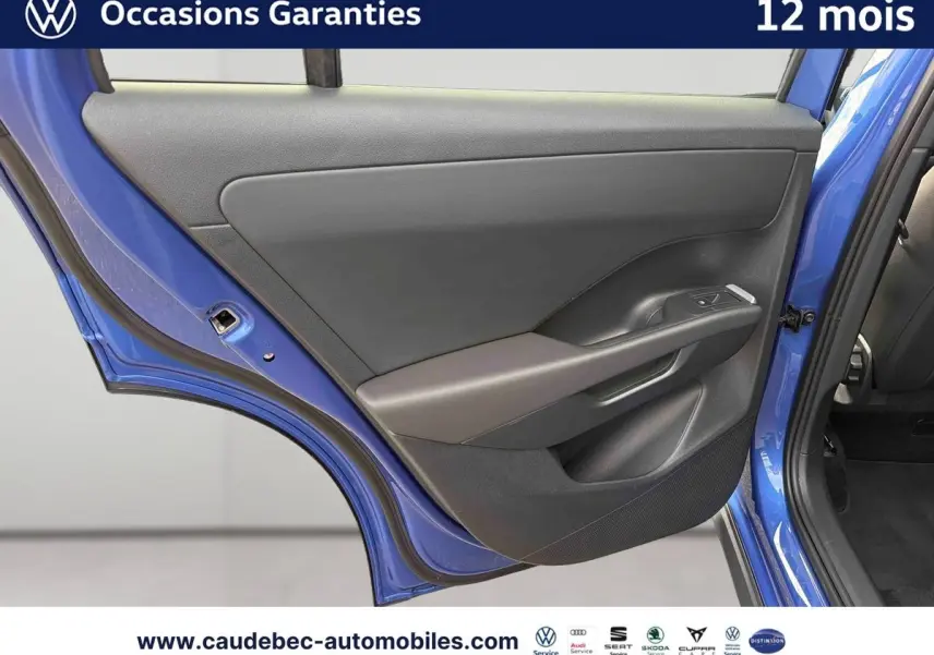 Vue rapprochée de la porte arrière gauche d’un Volkswagen T-Roc bleu métallisé avec garniture intérieure grise.