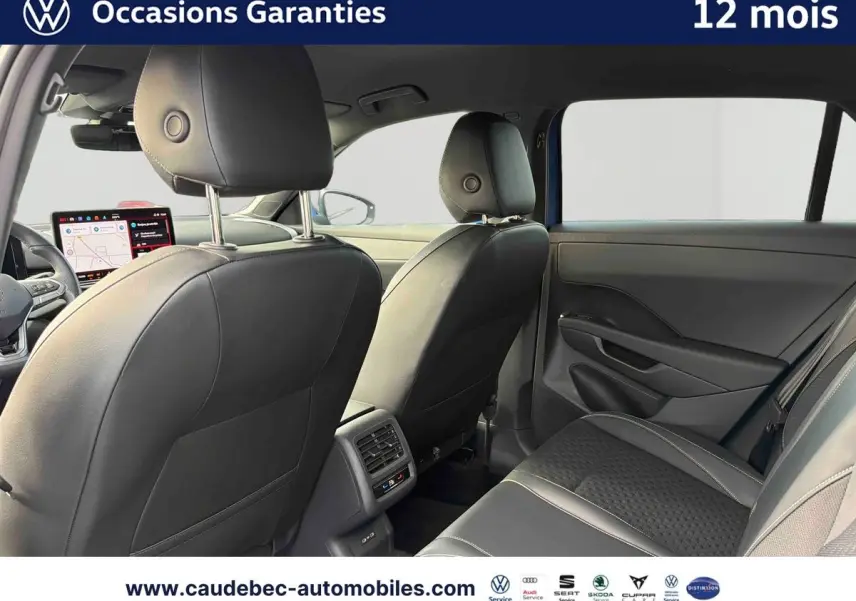 Vue intérieure arrière du Volkswagen T-Roc 2026 avec sièges en cuir noir et tableau de bord digital visible au loin.