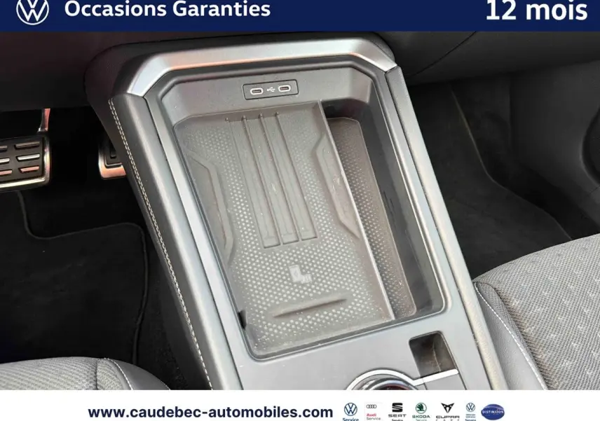 Vue rapprochée de la console centrale du Volkswagen T-Roc 2026 avec zone de recharge sans fil et finition sobre.