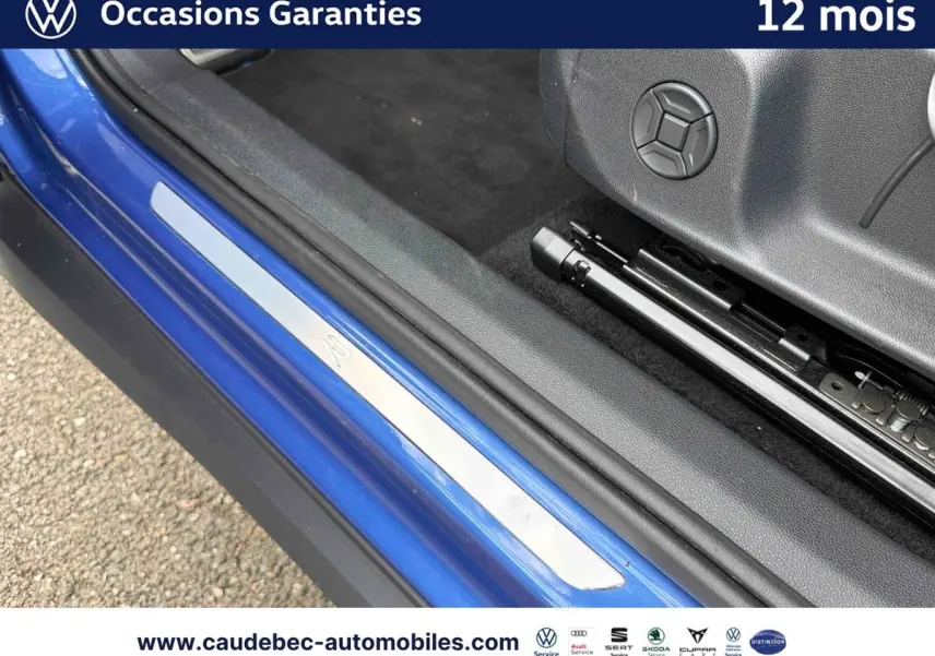 Détail de la porte côté conducteur d’un Volkswagen T-Roc bleu 2026 avec seuil de porte R et intérieur noir.