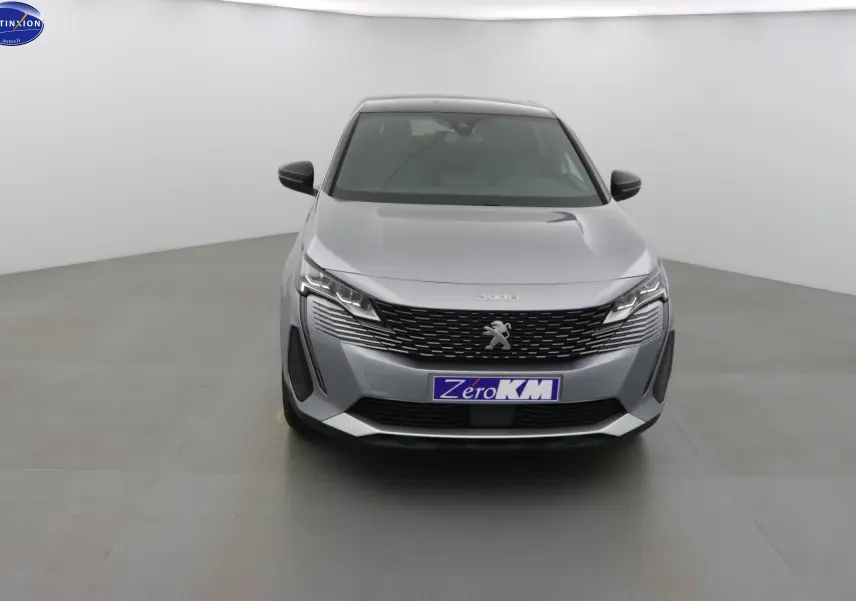 Vue frontale d'un Peugeot 3008 gris Artense métal 2023 avec calandre noire et feux LED distinctifs.