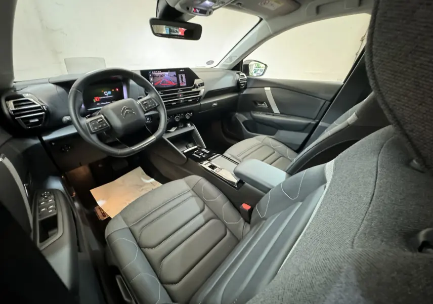 Intérieur de la Citroën C4 PureTech 130 EAT8 Shine 2023, vue côté conducteur, sièges gris et tableau de bord digital.