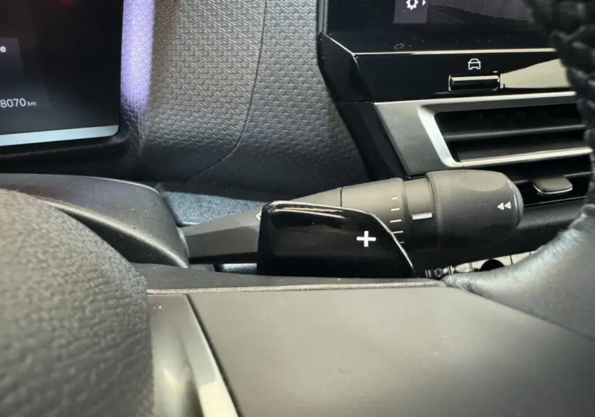 Gros plan sur la commande de palette de changement de vitesse + côté gauche du tableau de bord noir d'une Citroën C4 2023.