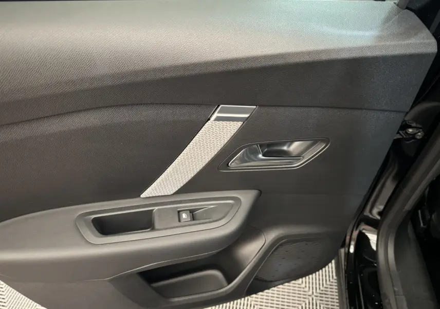 Gros plan sur la porte côté gauche de la Citroën C4 noire 2023, avec poignée argentée et bouton de verrouillage intégré.