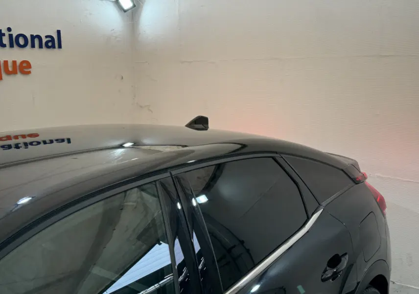 Vue côté droit arrière d'une Citroën C4 PureTech 130 EAT8 Shine noire avec vitres teintées et antenne requin.
