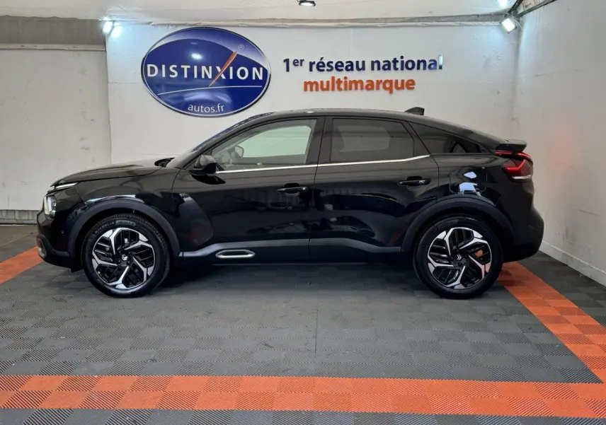 Profil côté gauche d'une Citroën C4 PureTech 130 EAT8 Shine noire, avec jantes modernes et ligne de toit dynamique.